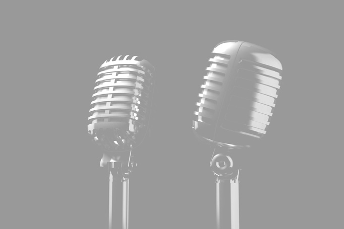 Black and white photo of 1950's style microphones on black background